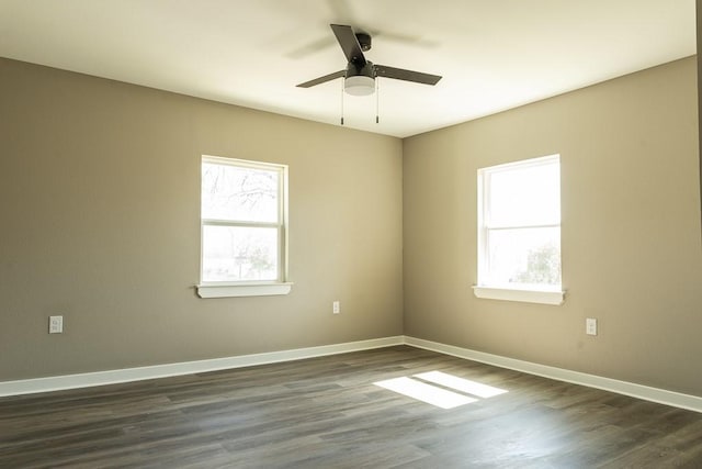 unfurnished room with dark wood-type flooring, a ceiling fan, and baseboards