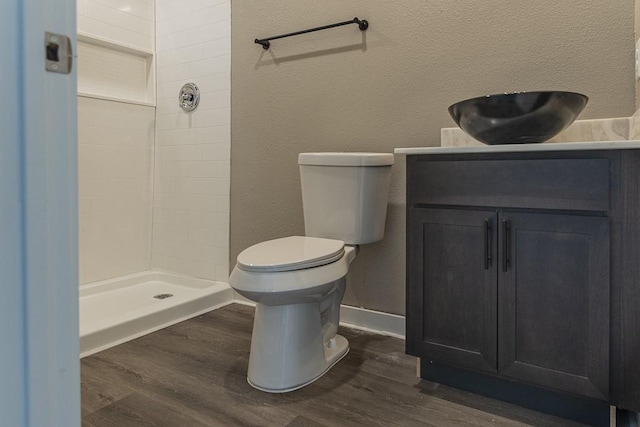 bathroom with vanity, a shower stall, toilet, and wood finished floors