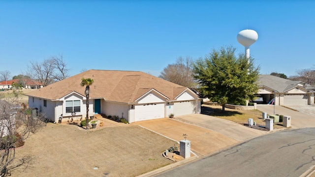 ranch-style house featuring a garage and concrete driveway