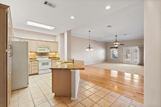 kitchen featuring light tile patterned floors, visible vents, cream cabinetry, and white appliances