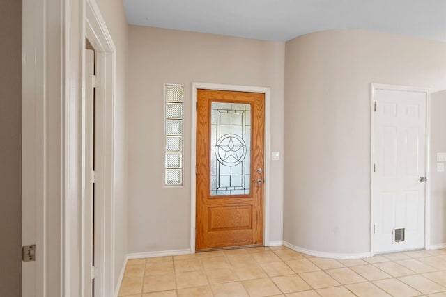 entryway with baseboards and light tile patterned floors