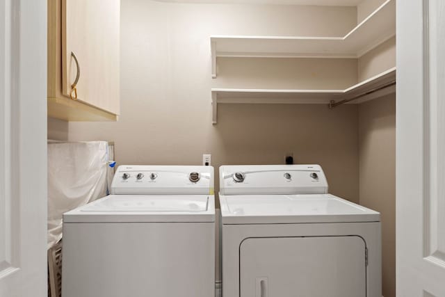 laundry room with washer and clothes dryer and cabinet space