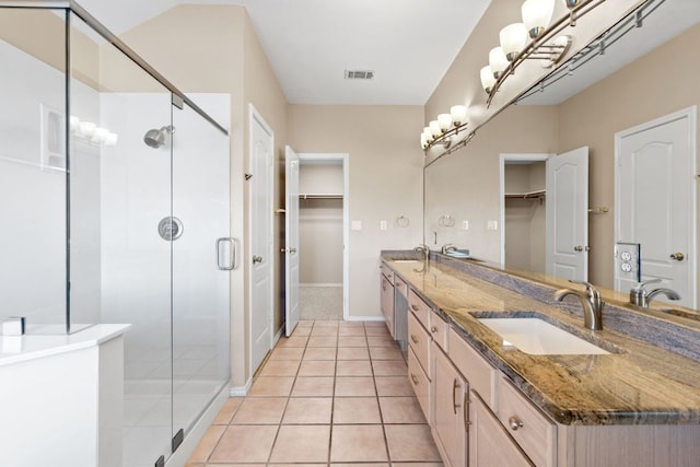 bathroom with double vanity, a sink, tile patterned floors, and a shower stall