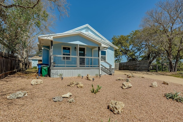 view of front of home with covered porch and fence