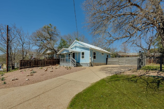 view of front of home featuring covered porch and fence