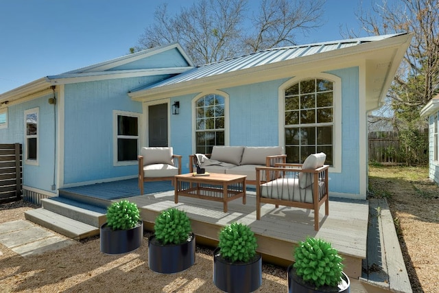 exterior space with outdoor lounge area, a deck, fence, and metal roof