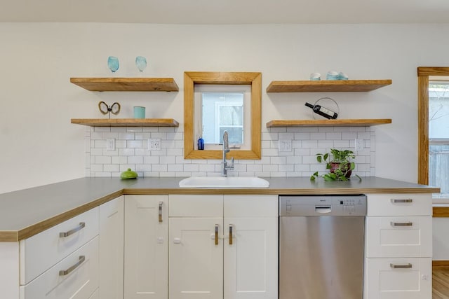 kitchen featuring a sink, open shelves, decorative backsplash, and stainless steel dishwasher