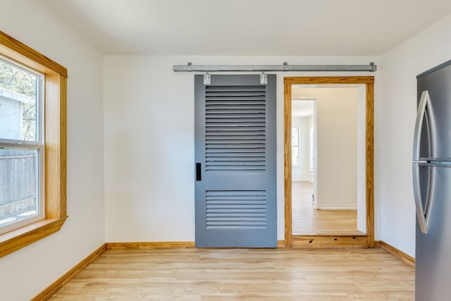 unfurnished room featuring baseboards and light wood-type flooring