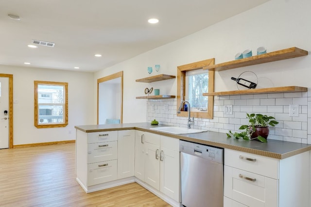 kitchen featuring open shelves, dishwasher, a wealth of natural light, and a sink