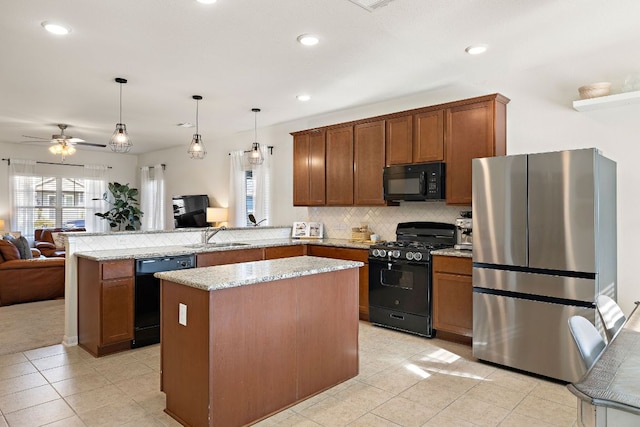 102 Tokalaun Dr, Hutto, TX 78634 - kitchen featuring black appliances, open floor plan, a peninsula, healthy amount of natural light, and recessed lighting
