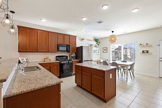 102 Tokalaun Dr, Hutto, TX 78634 - kitchen featuring black appliances, tasteful backsplash, brown cabinetry, light stone counters, and recessed lighting