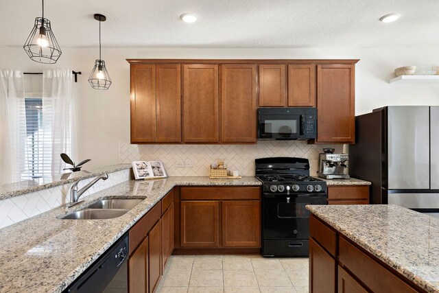 102 Tokalaun Dr, Hutto, TX 78634 - kitchen featuring black appliances, tasteful backsplash, light stone countertops, pendant lighting, and brown cabinetry
