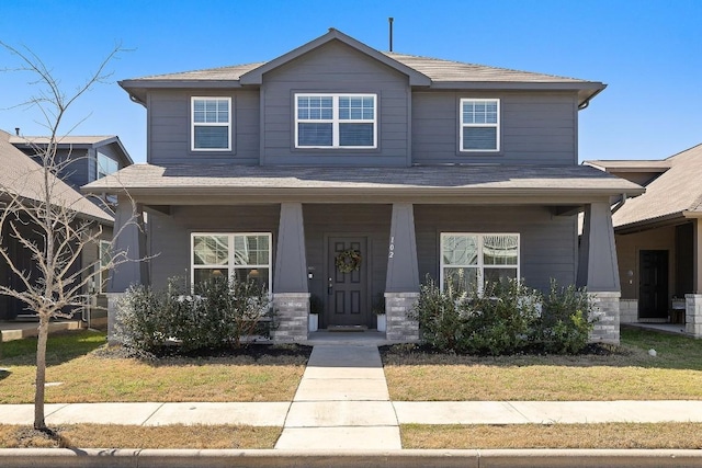 102 Tokalaun Dr, Hutto, TX 78634 - view of front facade with covered porch, a front yard, and stone siding