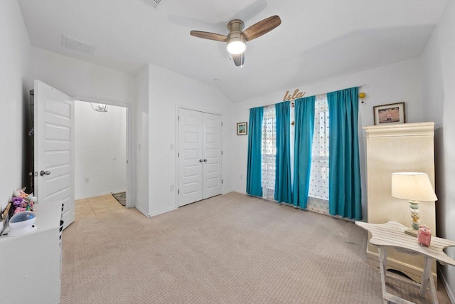 bedroom featuring visible vents, a closet, carpet flooring, lofted ceiling, and ceiling fan