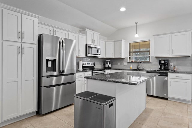 kitchen featuring lofted ceiling, light tile patterned floors, decorative backsplash, stainless steel appliances, and a sink