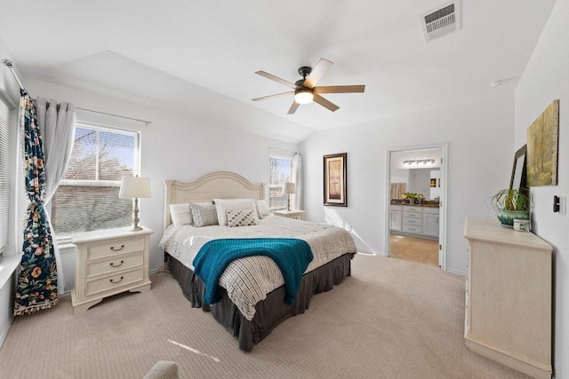 bedroom featuring visible vents, multiple windows, lofted ceiling, and light carpet