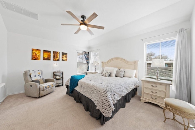 bedroom featuring visible vents, light colored carpet, and multiple windows