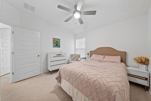 bedroom with visible vents, light colored carpet, a ceiling fan, and vaulted ceiling