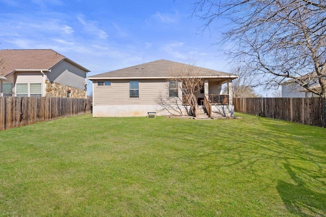 back of property featuring a yard, a fenced backyard, and a shingled roof