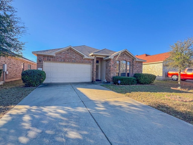 ranch-style home featuring an attached garage, a shingled roof, concrete driveway, a front lawn, and brick siding