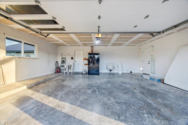 garage featuring black refrigerator with ice dispenser