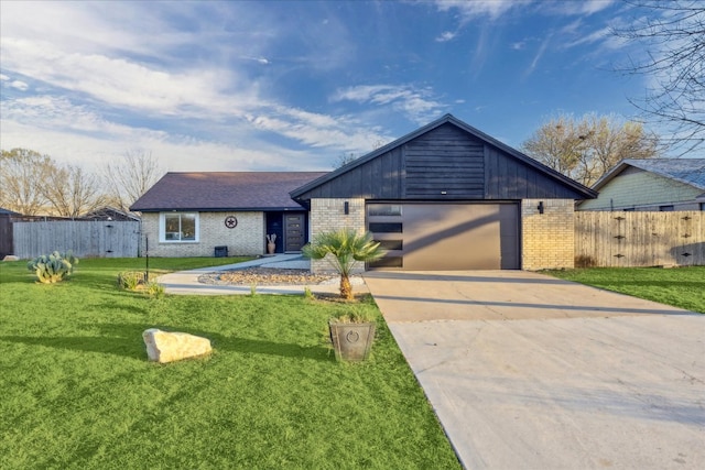 view of front of house with a front lawn, fence, brick siding, and driveway