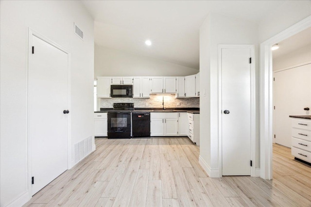 kitchen featuring dark countertops, visible vents, black appliances, and decorative backsplash