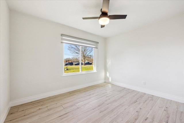 unfurnished room with baseboards, light wood-style flooring, and a ceiling fan