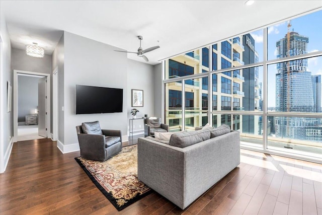 living room with baseboards, a ceiling fan, dark wood-style floors, and floor to ceiling windows