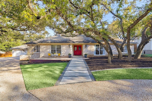 ranch-style house with stone siding and a front lawn