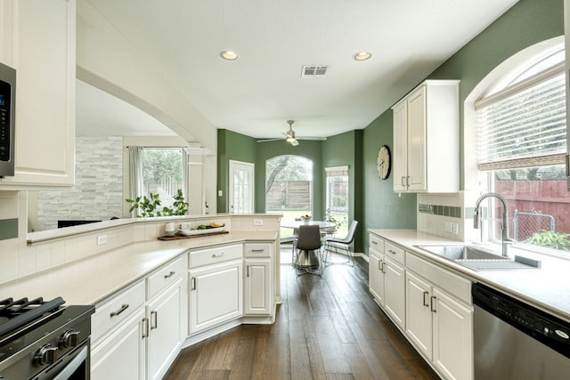 kitchen with a sink, white cabinets, tasteful backsplash, and stainless steel appliances