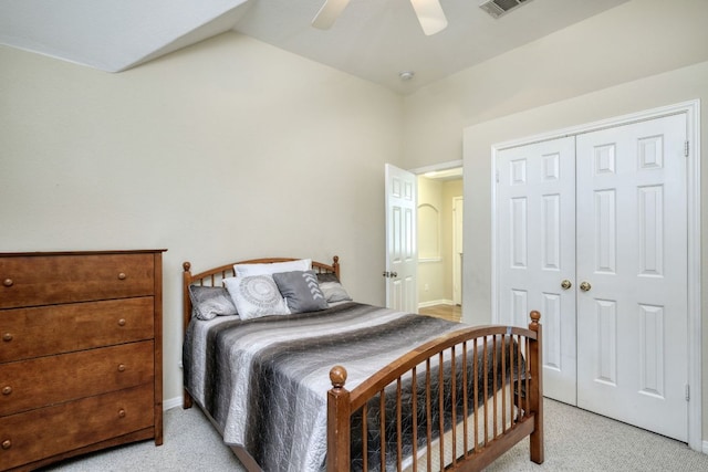 bedroom with visible vents, light carpet, a ceiling fan, a closet, and vaulted ceiling