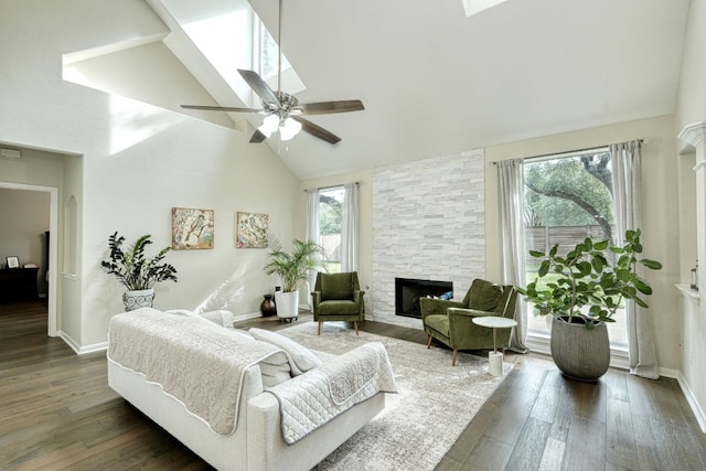 living room featuring a healthy amount of sunlight, a fireplace, high vaulted ceiling, and wood finished floors