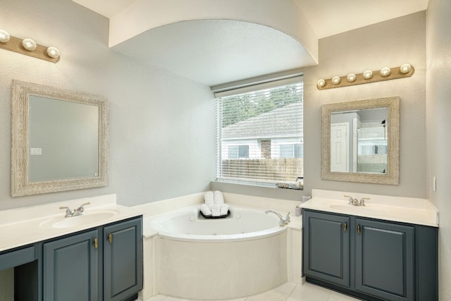 full bath with a bath, tile patterned floors, two vanities, and a sink