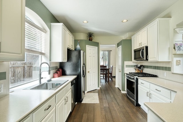 kitchen featuring a sink, stainless steel appliances, light countertops, and white cabinetry