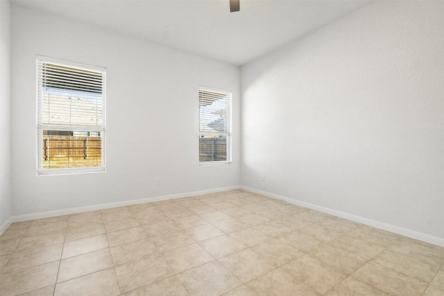 spare room featuring baseboards and ceiling fan