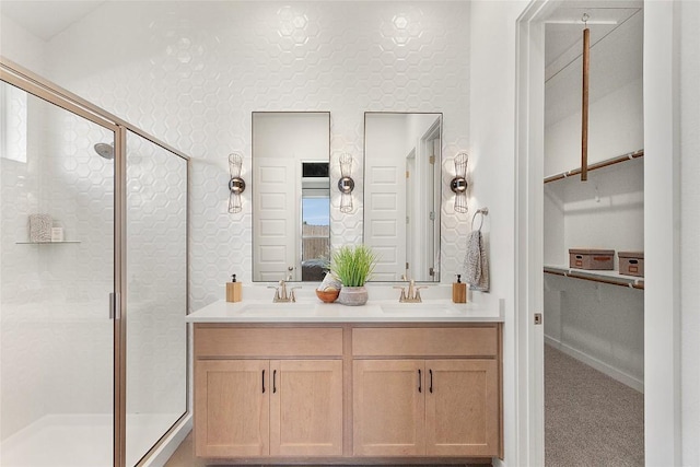 full bath with double vanity, a shower stall, ensuite bathroom, and a sink