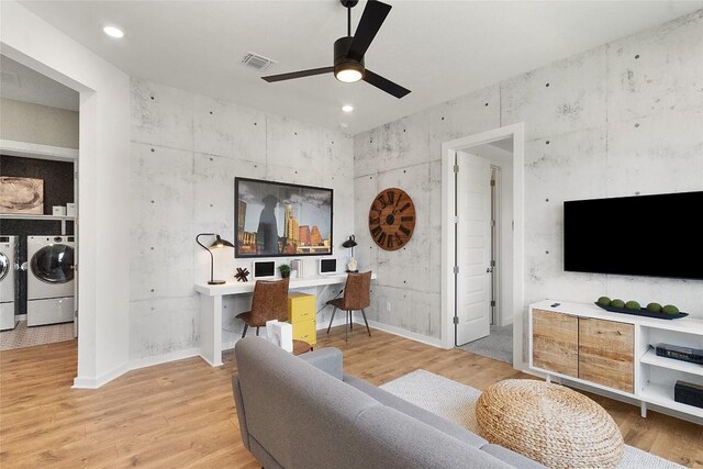 living room with visible vents, separate washer and dryer, light wood-type flooring, and ceiling fan