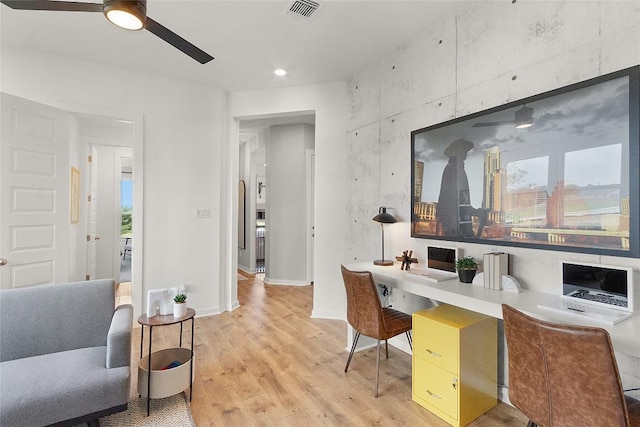 office space with visible vents, light wood-style floors, baseboards, a healthy amount of sunlight, and ceiling fan
