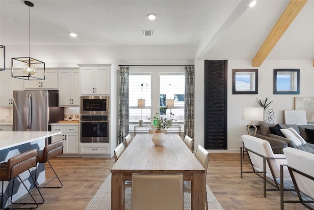 kitchen featuring decorative light fixtures, light wood finished floors, appliances with stainless steel finishes, and light countertops