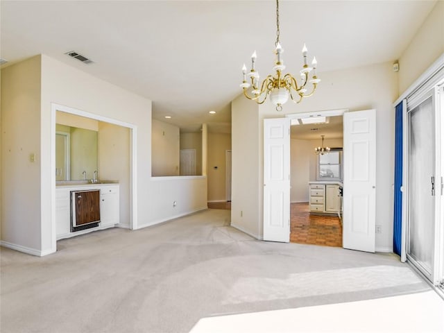 unfurnished dining area featuring visible vents, baseboards, recessed lighting, a notable chandelier, and light colored carpet