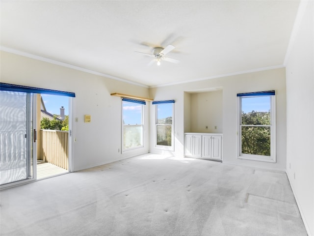 unfurnished room featuring a wealth of natural light, carpet, and ornamental molding