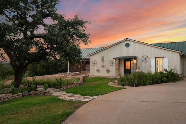 mid-century home featuring a front yard, a standing seam roof, and metal roof