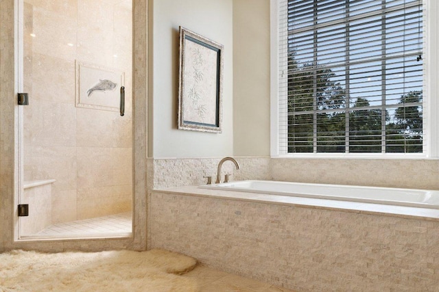 bathroom featuring a garden tub, a shower stall, and tile patterned flooring