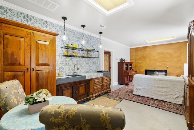 interior space featuring wallpapered walls, decorative light fixtures, ornamental molding, brown cabinets, and a sink