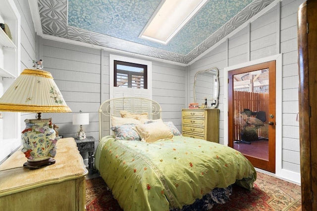 bedroom with lofted ceiling and wood walls