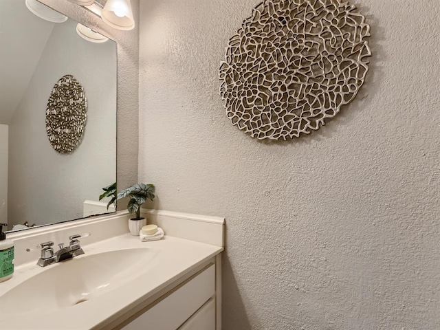 bathroom with vanity and a textured wall