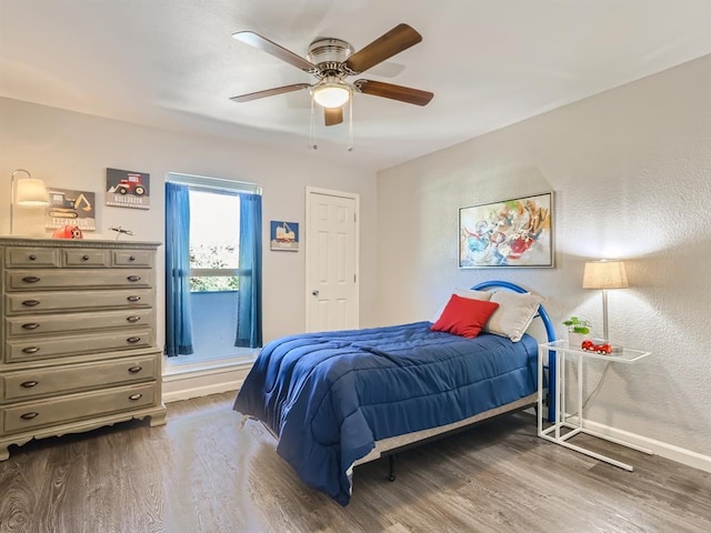 bedroom featuring a ceiling fan, wood finished floors, and baseboards