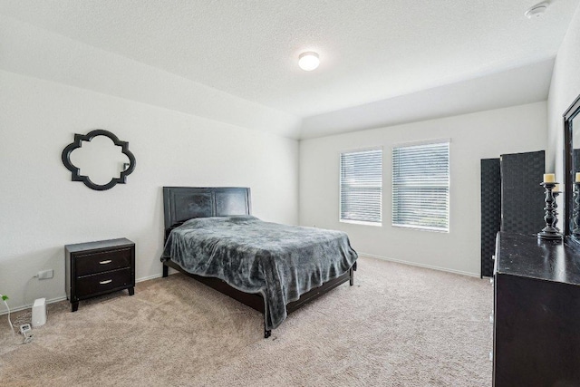 bedroom with a textured ceiling, baseboards, and carpet floors