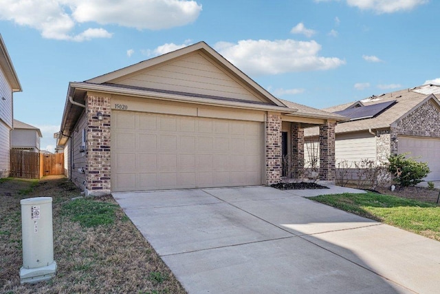 ranch-style home featuring brick siding, concrete driveway, an attached garage, and fence